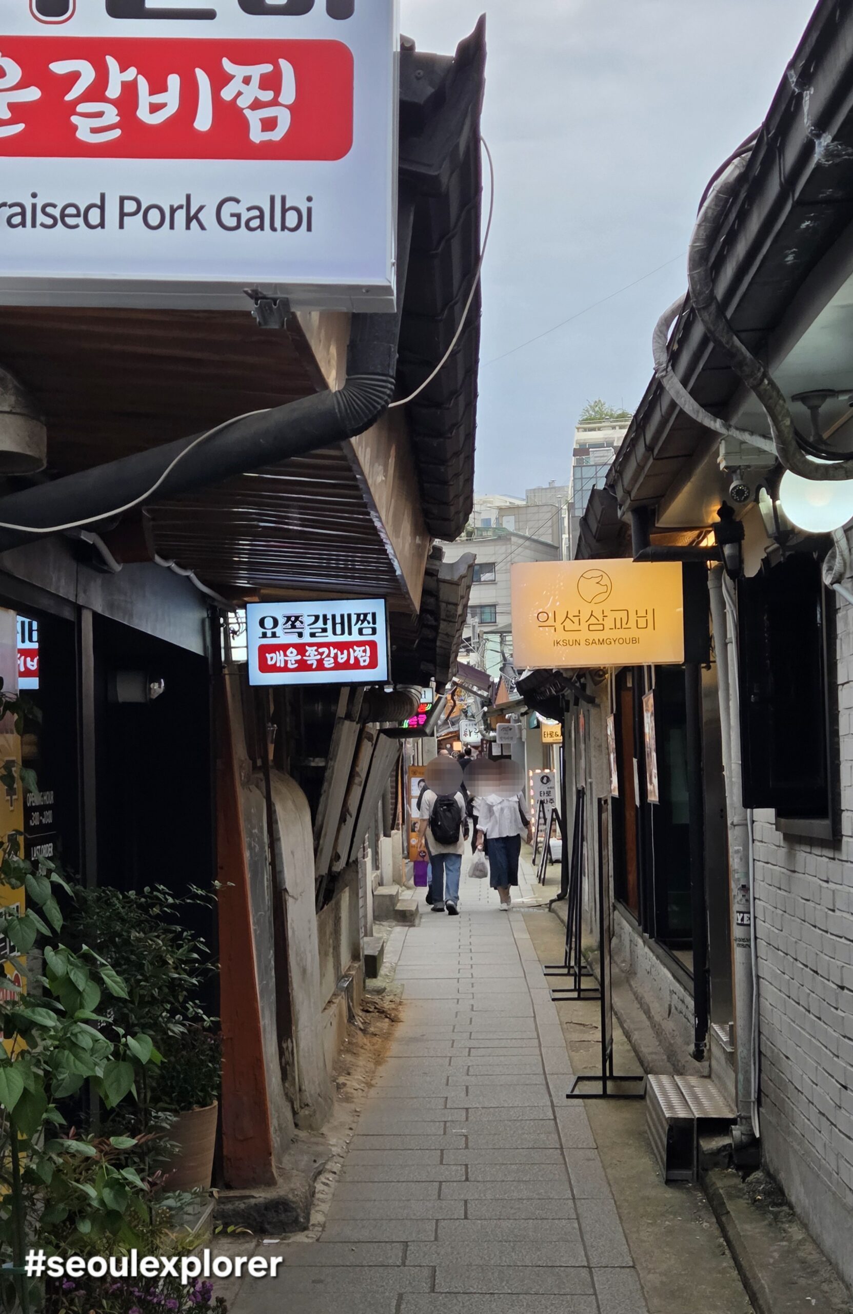 Narrow alleyway of Ikseon-dong Hanok Village with traditional houses and modern shops