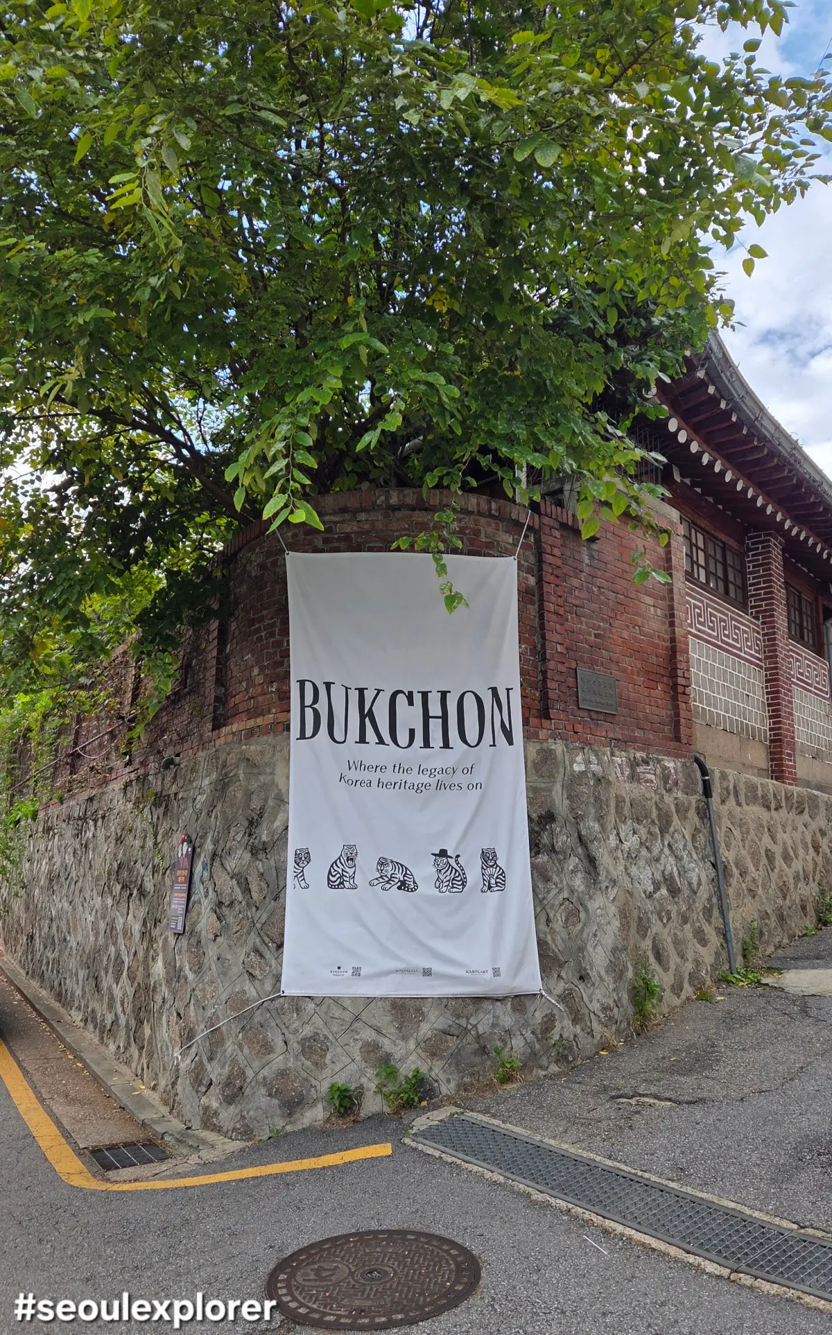 Entrance of Bukchon Hanok Village with a guide banner for visitors