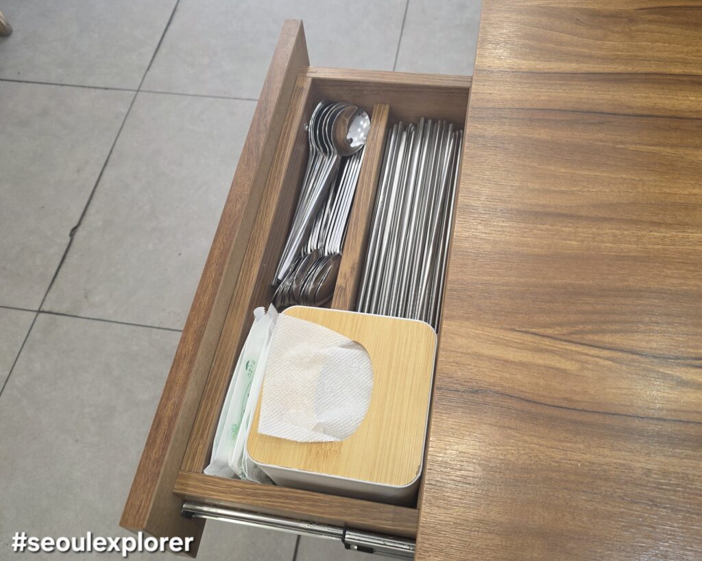 A hidden utensil drawer under a table in a Korean restaurant