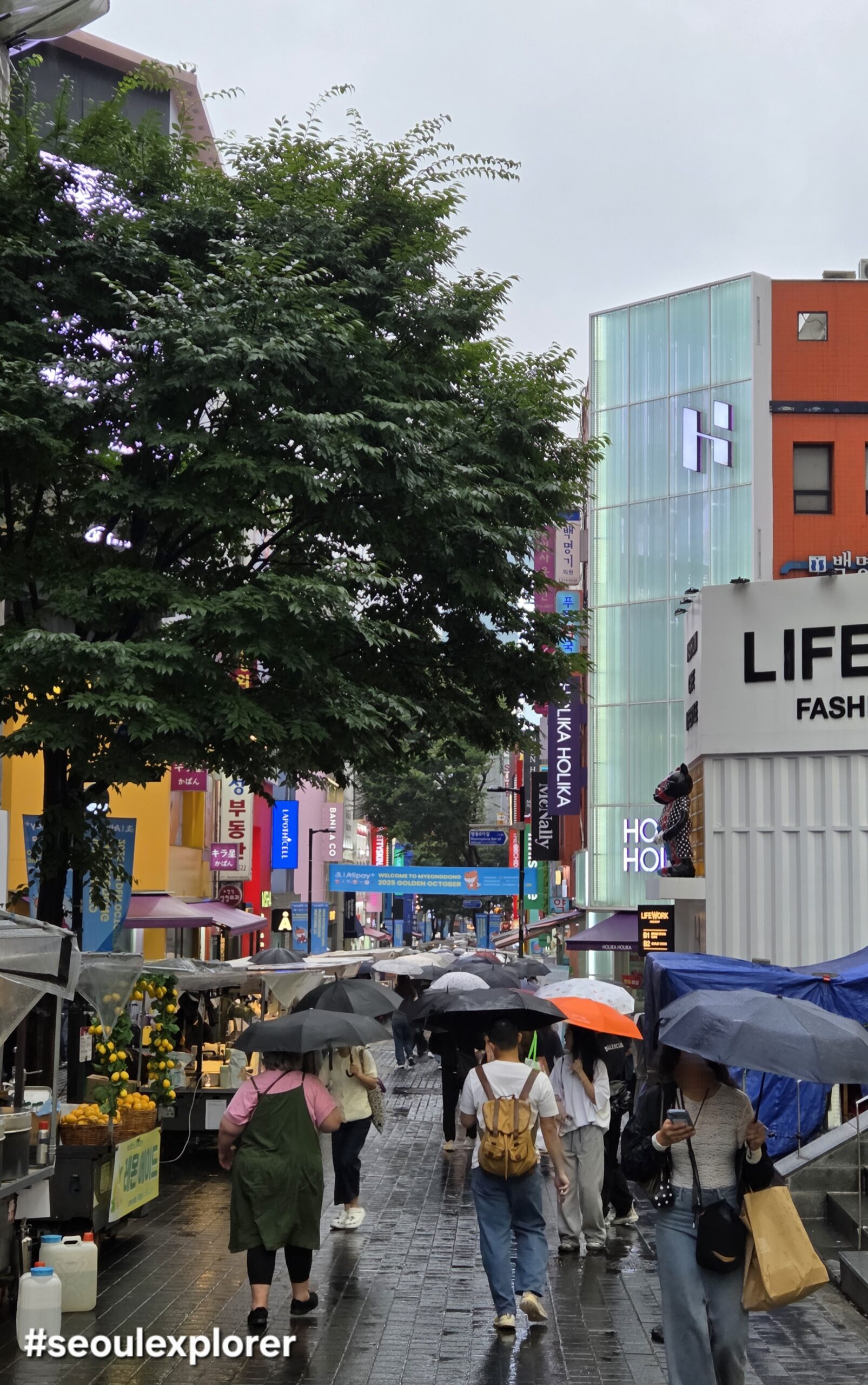 Crowded shopping street for a Myeongdong Seoul Guide on a rainy day