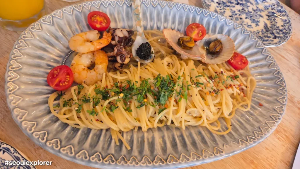 Seafood pasta with shrimp and scallops on a blue plate