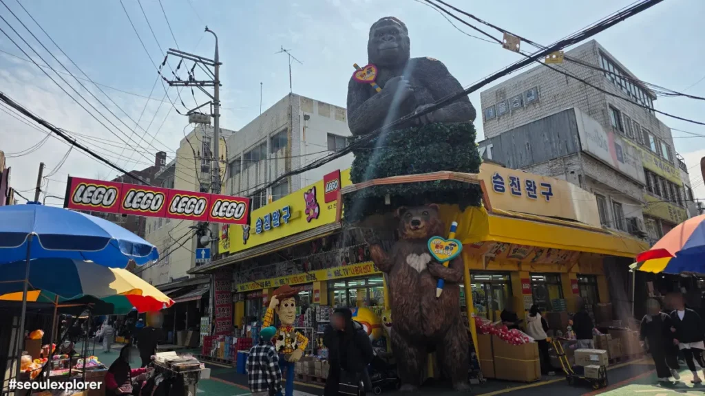 Seungjin Toys storefront featuring iconic giant gorilla and Lego statues